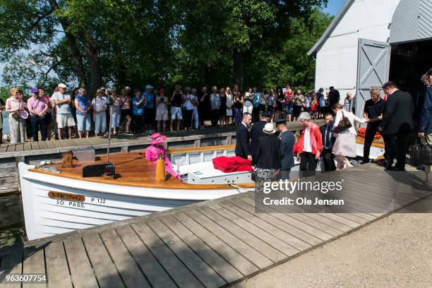 Queen Margrethe of Denmark is helped by Jakob Ellemann-Jensen , Minister of Environment and Agriculture, to board the small boat, which will take...