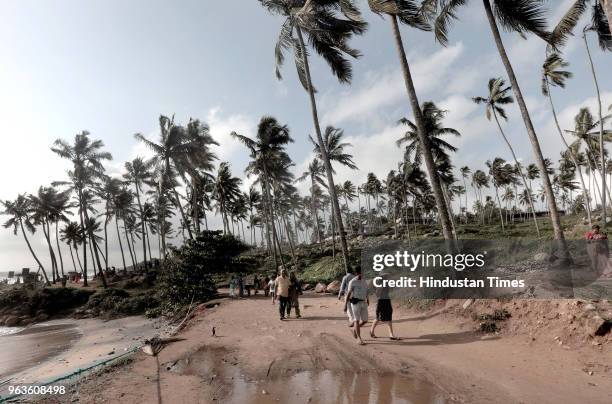 People stroll by the Kovalam Beach on May 29, 2018 in Thiruvananthapuram, India. The south-west monsoon arrived in Kerala and Tamil Nadu on Tuesday,...