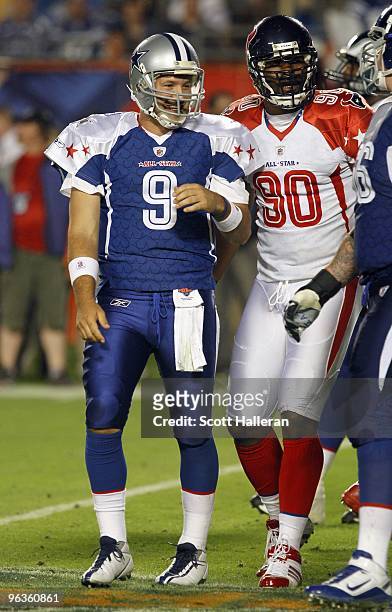 Quarterback Tony Romo of the NFC's Dallas Cowboys and Mario Williams of the AFC's Houston Texans look on after a play during the 2010 AFC-NFC Pro...