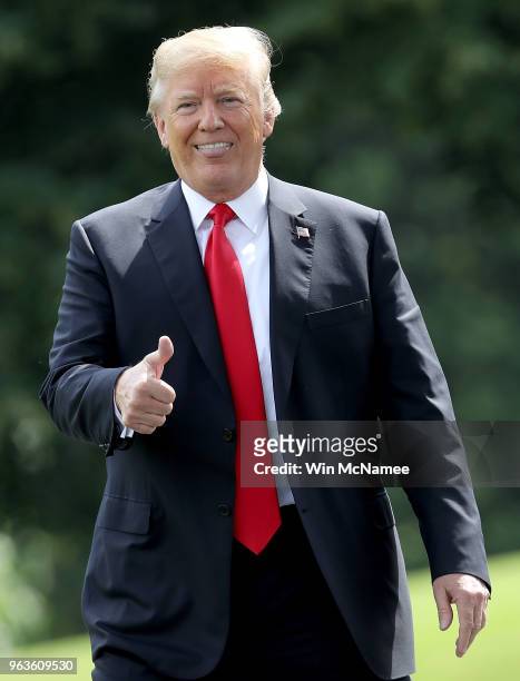 President Donald Trump gestures toward journalists shouting questions as he departs the White House May 29, 2018 in Washington, DC. Trump is...
