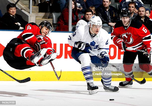 Alexei Ponikarovsky of the Toronto Maple Leafs trips up Dainius Zubrus of the New Jersey Devils during game action February 2, 2010 at the Air Canada...