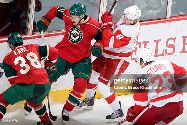 Robbie Earl and James Sheppard of the Minnesota Wild battle for the puck with Justin Abdelkader and Brad Stuart of the Detroit Red Wings during the...