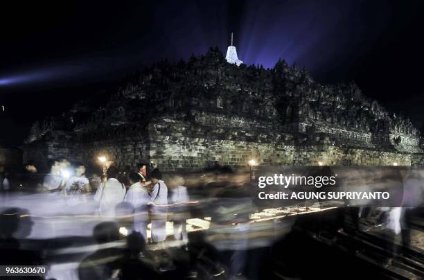 This picture taken on May 29, 2018 shows Buddhist monks and devotees conducting prayers at the Borobudur temple in Magelang, Central Java on Vesak...