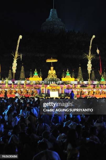 This picture taken on May 29, 2018 shows Buddhist monks and devotees conducting prayers at the Borobudur temple in Magelang, Central Java on Vesak...