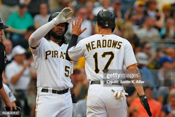 Josh Bell of the Pittsburgh Pirates celebrates with Austin Meadows of the Pittsburgh Pirates after scoring on a RBI double in the first inning...
