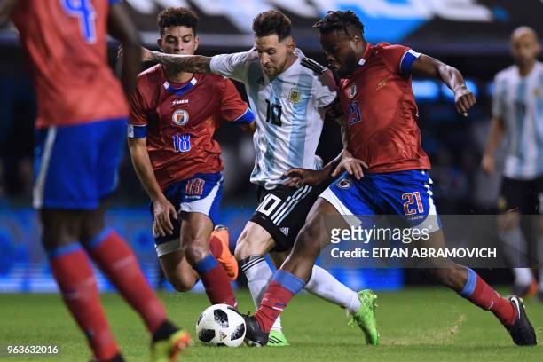 Argentina's Lionel Messi is marked by Haiti's Steeven Sabat and Bryan Chevreuil during their international friendly football match at Boca Juniors'...