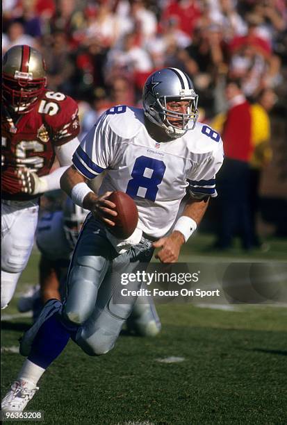 Quarterback Troy Aikam of the Dallas Cowboys drops back to pass with defensive end Chris Doleman of the San Francisco 49ers putting the pressure...