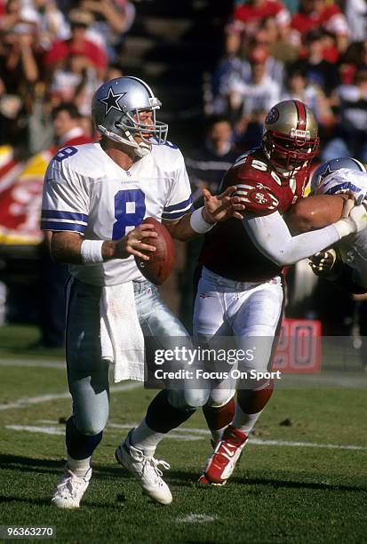 Quarterback Troy Aikam of the Dallas Cowboys drops back to pass with defensive end Chris Doleman of the San Francisco 49ers putting the pressure...