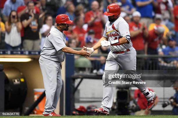 Francisco Pena of the St. Louis Cardinals is congratulated by third base coach Jose Oquendo after a home run in the eighth inning of a game against...