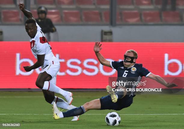 Peru's Luis Advincula strikes the ball past Scotland's Dylan McGeouch during their international friendly football match at the National Stadium in...
