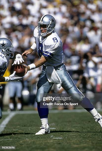 Quarterback Troy Aikam of the Dallas Cowboys turns to hand the ball off to running back Emmit Smith during a mid circa 1990's NFL football game....
