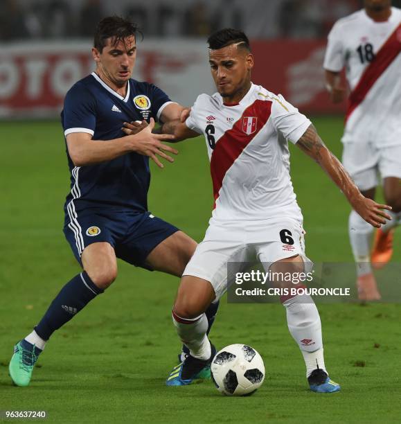 Scotland's Kenny McLean vies for the ball with Peru's Miguel Trauco during their international friendly football match at the National Stadium in...