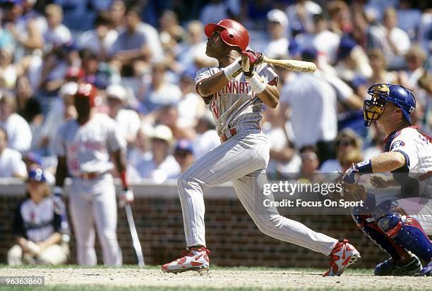 Shortstop Barry Larkin of the Cincinnati Reds swings and watches the flight of his ball against the Chicago Cubs during a circa 1995 MLB baseball...