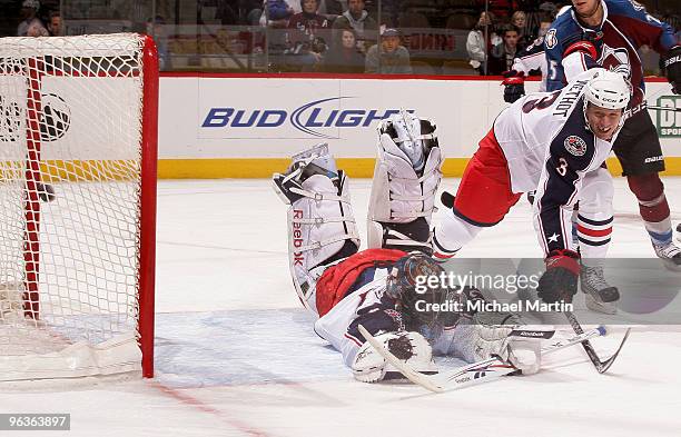 Goaltender Mathieu Garon of the Columbus Blue Jackets misses a save as Marc Methot helps defend against the Colorado Avalanche at the Pepsi Center on...