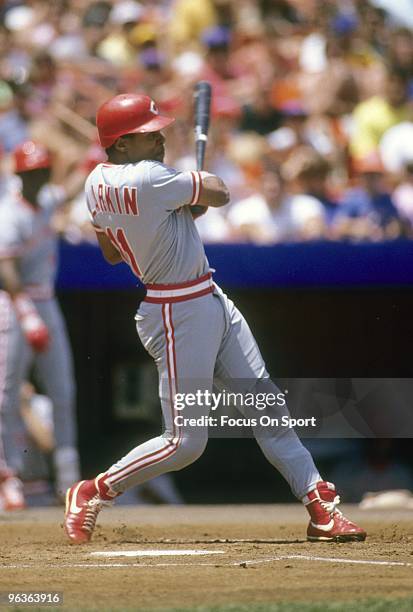 S: Shortstop Barry Larkin of the Cincinnati Reds swings and watches the flight of his ball against the New York Mets during a MLB baseball game circa...