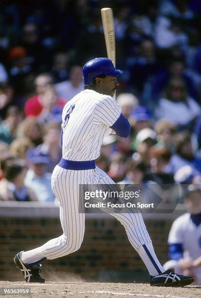 S: Outfielder Andre Dawson of the Chicago Cubs swings and watches the flight of his ball during a late circa 1980's Major League Baseball game at...