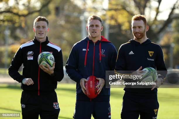 St Kilda's Ray Connellan, Qantas Wallabies superboot Reece Hodge and Hawthorn's Conor Glass pose outside AAMI park on May 30, 2018 in Melbourne,...