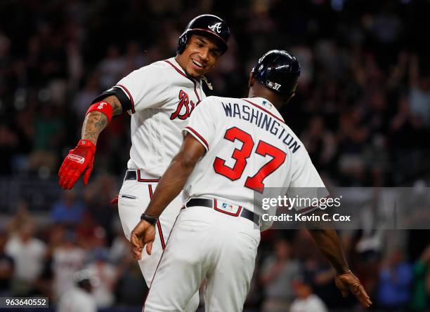 Johan Camargo of the Atlanta Braves celebrates with third base coach Ron Washington after hitting a walk-off homer in the ninth inning of a 7-6 win...