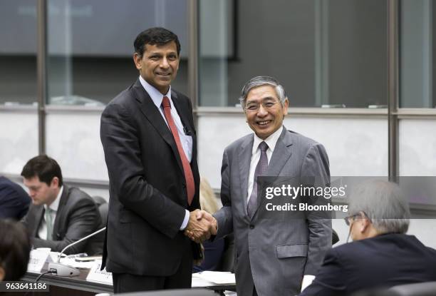 Raghuram Rajan, former governor of the Reserve Bank of India , left, and Haruhiko Kuroda, governor of the Bank of Japan , shake hands while posing...