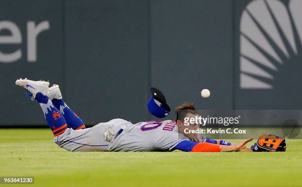 Michael Conforto of the New York Mets dives but fails to catch a single hit by Dansby Swanson of the Atlanta Braves in the eighth inning at SunTrust...