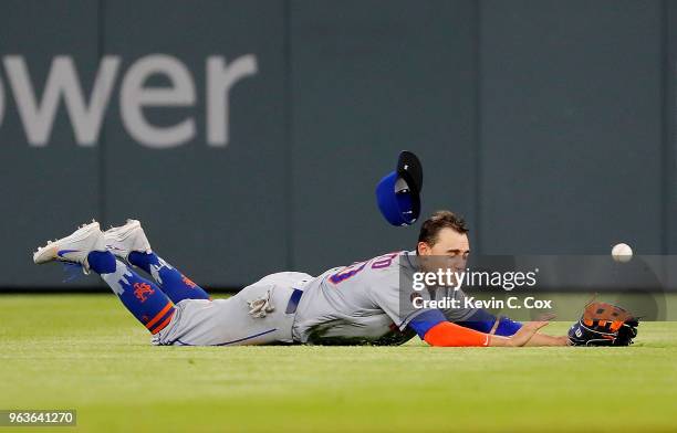 Michael Conforto of the New York Mets dives but fails to catch a single hit by Dansby Swanson of the Atlanta Braves in the eighth inning at SunTrust...