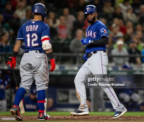 Nomar Mazara of the Texas Rangers crosses home plate in front of Rougned Odor of the Texas Rangers to score a run on a wild pitch by relief pitcher...