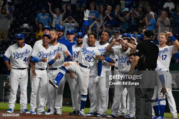 Members of the Kansas City Royals waits at home for Alcides Escobar after Escobar hit a walk-off home run in the 14th inning against the Minnesota...