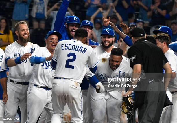 Alcides Escobar of the Kansas City Royals is congratulated by teammates after hitting a walk-off home run in the 14th inning against the Minnesota...