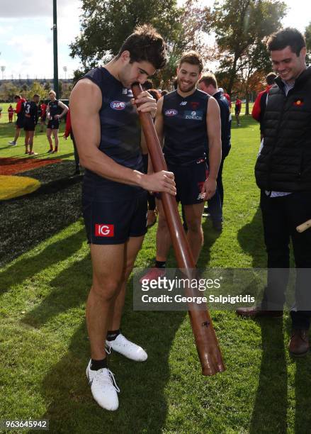Christian Petracca of the Demons trys to play the didgeridoo after a Melbourne Demons training session at Gosch's Paddock on May 30, 2018 in...