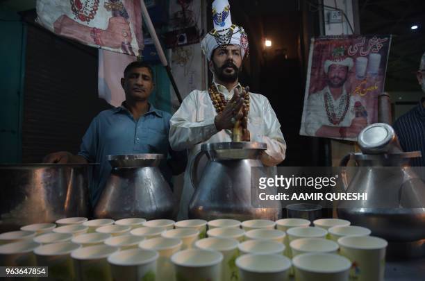 Pakistani vendor makes lassi for residents during sehri before beginning their Ramadan fast at Kartarpura 'food street' in Rawalpindi on May 30,...