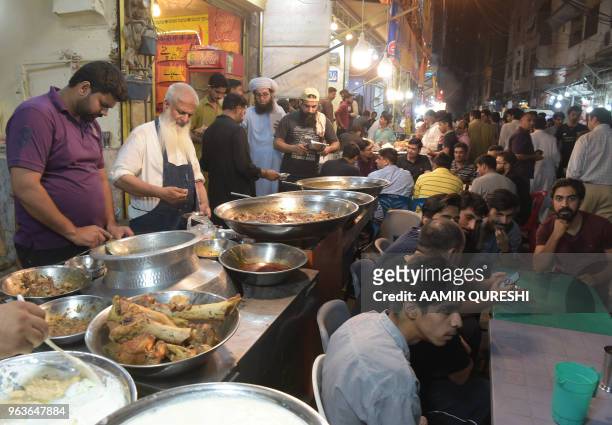 Pakistani residents wait to eat sehri before beginning their Ramadan fast at Kartarpura 'food street' in Rawalpindi on May 30, 2018. - Muslims...