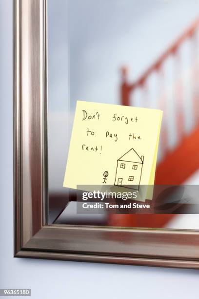 post-it note with rent reminder on mirror - paid palabra en inglés fotografías e imágenes de stock