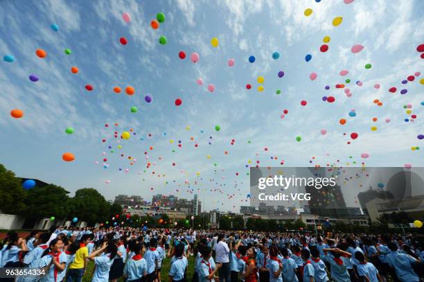 Students free balloons to welcome the upcoming International Children's Day at Yucai primary school on May 30, 2018 in Yangzhou, China. International...