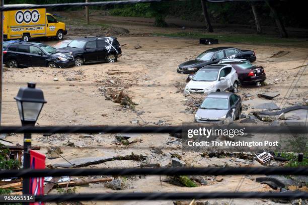 Destroyed parked cars are stranded in the mud May 28, 2018 in Ellicott City, MD. This comes two years after another flash flood killed two people and...