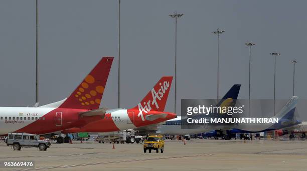 This photograph taken on March 8, 2018 shows an airplane of Air Asia, the low-cost airline headquartered in Malaysia, parked with other airliners at...