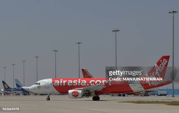 This photograph taken on March 8, 2018 shows an airplane of Air Asia, the low-cost airline headquartered in Malaysia, returning to park after landing...
