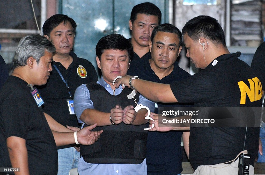 Andal Ampatuan Jnr. (C), is handcuffed b