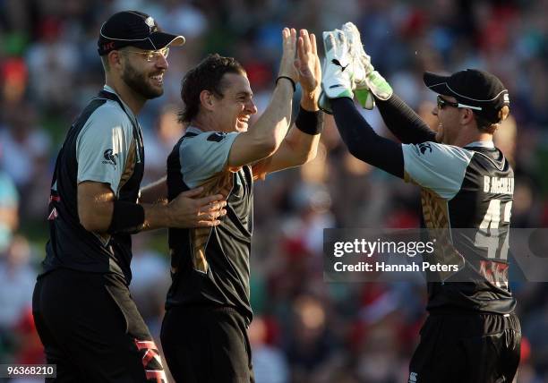 Nathan McCullum celebrates with Daniel Vettori and Brendon McCullum of New Zealand after bowling Shakib Al HasanÊof Bangladesh out during the...