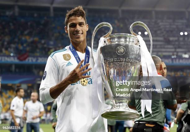 Raphael Varane of Real Madrid celebrates with The UEFA Champions League trophy following his sides victory in the UEFA Champions League Final between...
