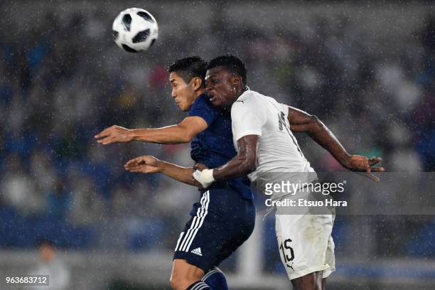 Yoshinori Muto of Japan and Rashid Sumaila of Ghana compete for the ball during the international friendly match between Japan and Ghana at Nissan...