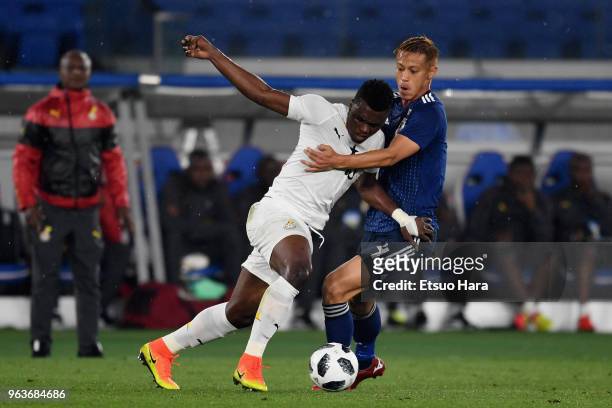 Rashid Sumaila of Ghana and Keisuke Honda of Japan compete for the ball during the international friendly match between Japan and Ghana at Nissan...