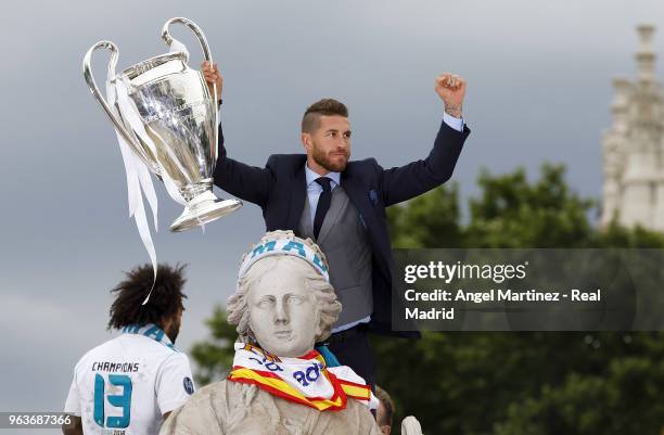 Captain Sergio Ramos of Real Madrid holds up the Champions League trophy at Cibeles Square a day after winning their 13th European Cup and UEFA...