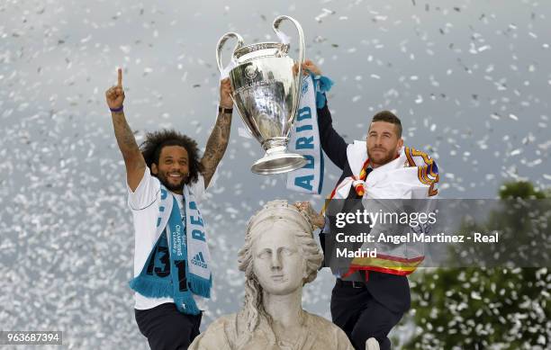 Captain Sergio Ramos of Real Madrid holds up the Champions League trophy with his teammate Marcelo as they celebrate at Cibeles Square a day after...