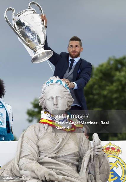 Captain Sergio Ramos of Real Madrid holds up the Champions League trophy at Cibeles Square a day after winning their 13th European Cup and UEFA...