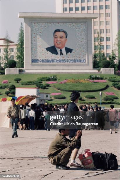 Street scene with Kim Il Sung image, soldiers and civilians in Pjoenjang, the capital of the People's Republic of North Korea .