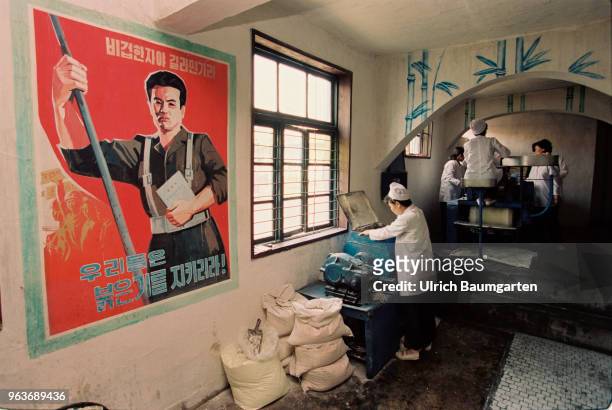Bakers in a bakery in Hwasan. On the wall a propaganda poster.
