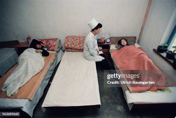 Hospital room with patients and a female doctor in a hospital in Hwasan.