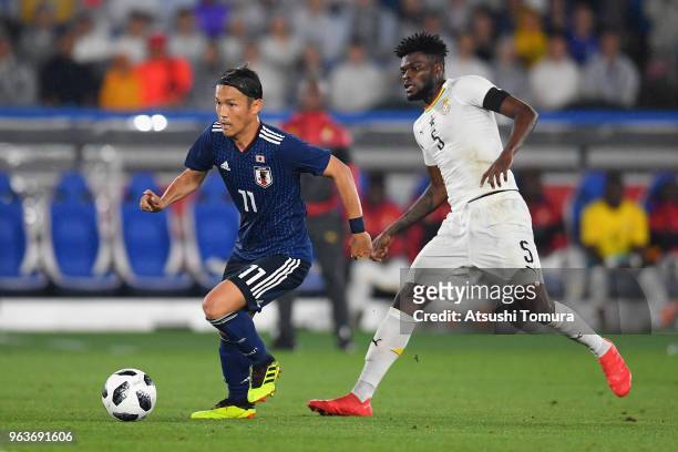 Takashi Usami of Japan and Thomas Partey of Ghana compete for the ball during the international friendly match between Japan and Ghana at Nissan...