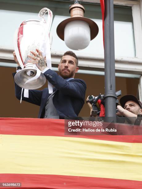 Real Madrid's Spanish defender Sergio Ramos holds the trophy from the balcony of the headquarters of the regional government of Madrid at the Puerta...
