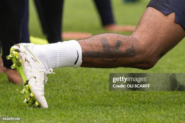 England's midfielder Raheem Sterling displays a tattoo of an assault rifle on his lower leg during a training session at St George's Park in...